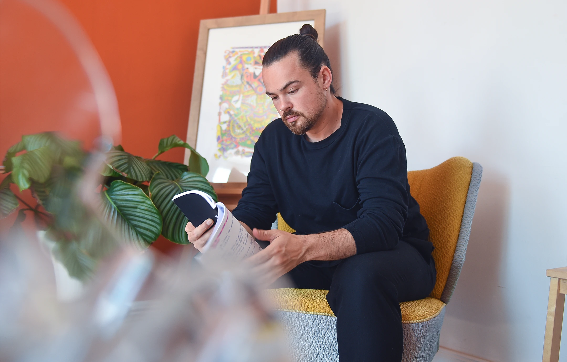 Dragan Vidovic sitzt auf einem Sessel, hält ein Notizbuch in der Hand und denkt über das nächste Digital Brand Design nach.